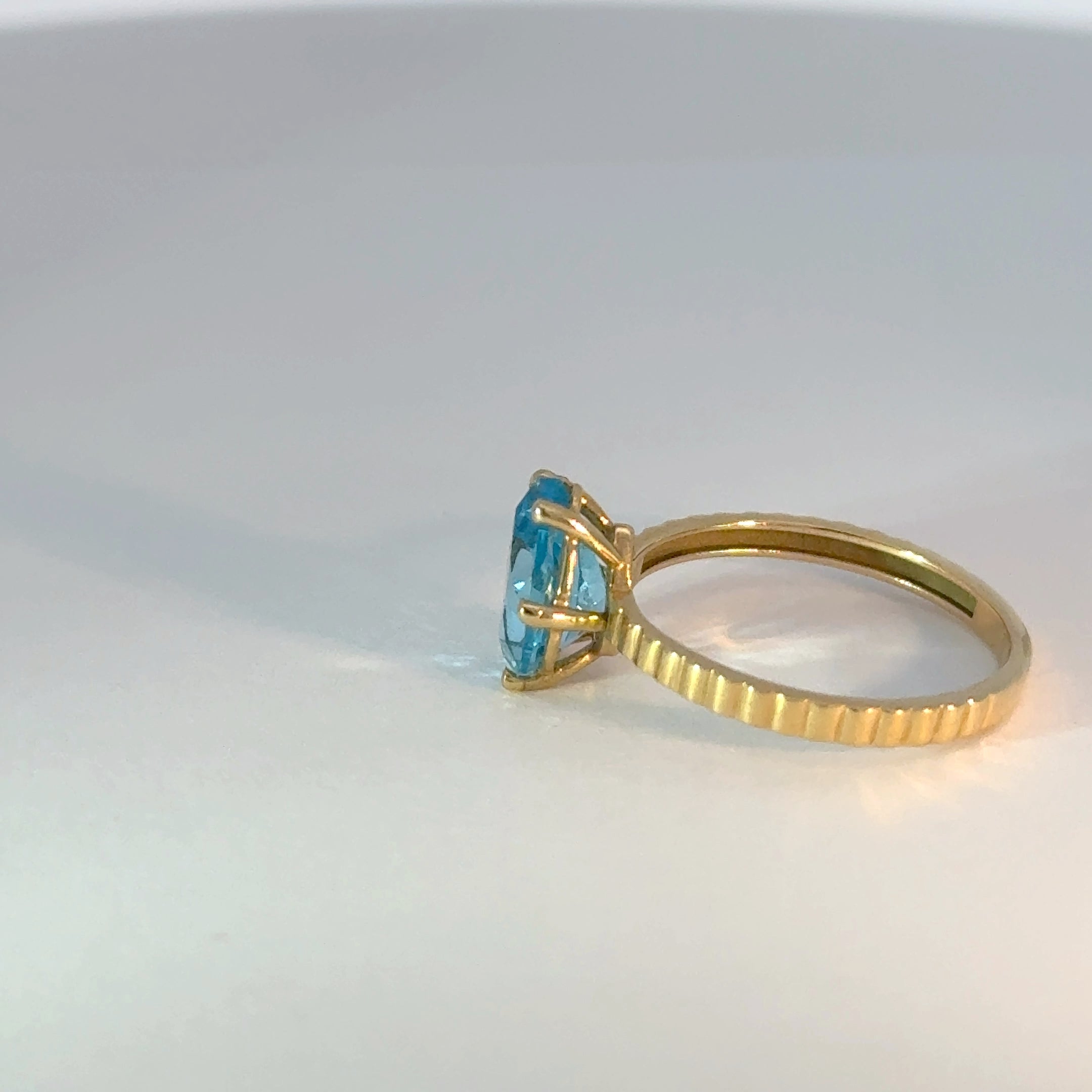 Anillo solitario de oro con topacio azul en forma de pera