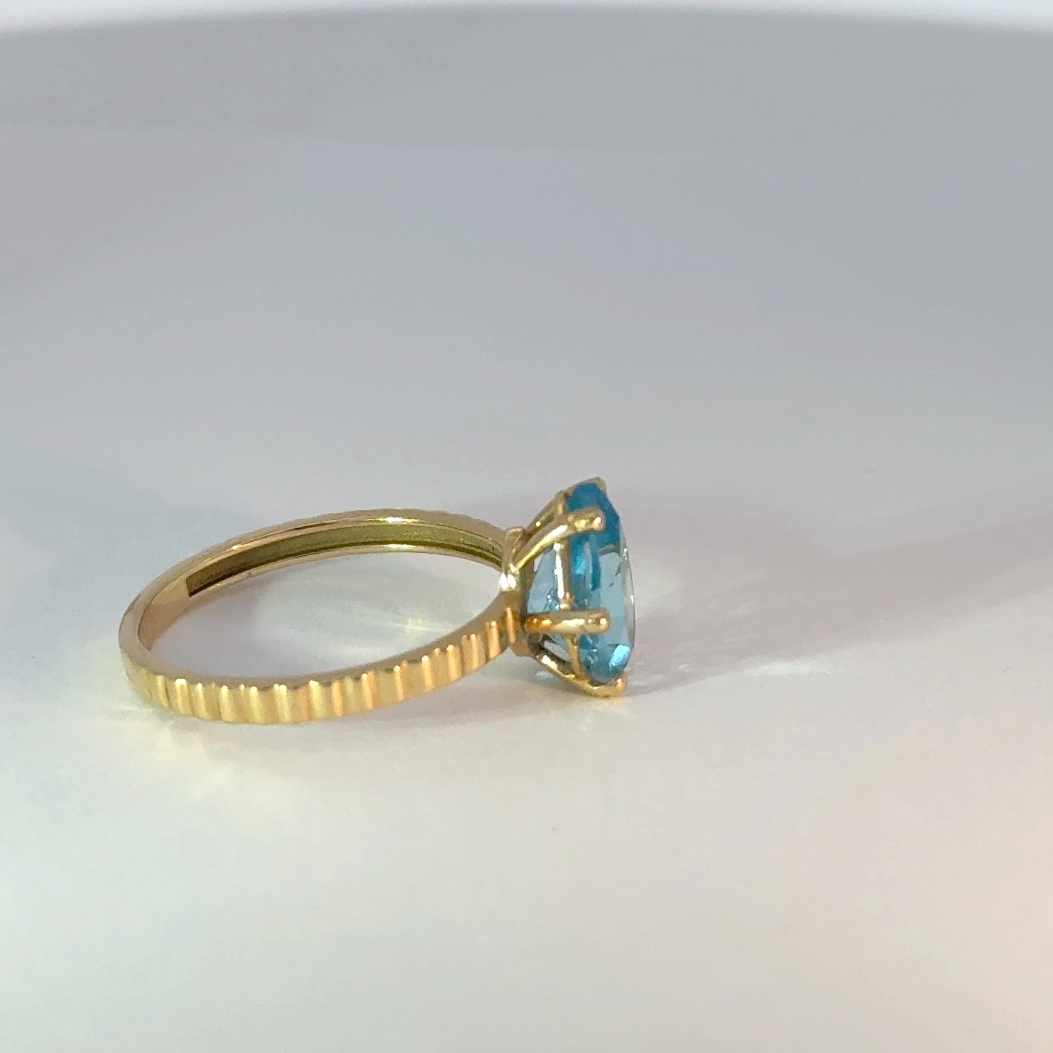 Anillo solitario de oro con topacio azul en forma de pera